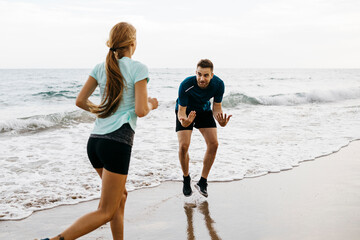 Female jogger on the beach with her coach