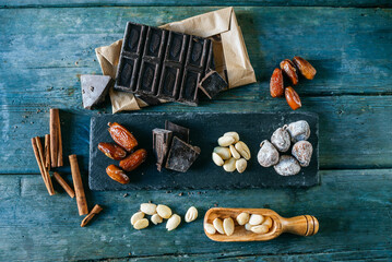 Dates, dark chocolate, almonds, cinnamon sticks and dried figs on wood