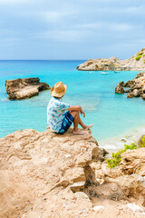 Man sitting on cliff looking at sea, Ibiza, Spain