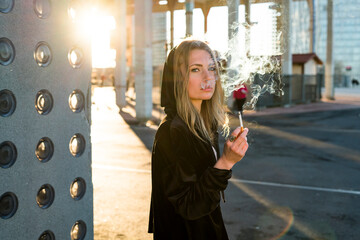 Portrait of blond young woman smoking cigarette