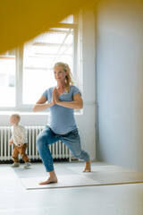 Pregnant woman with toddler son practicing yoga