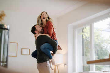 Man lifting and embracing his cheering wife