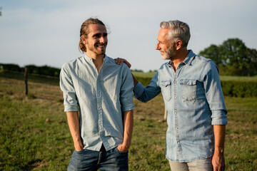 Happy father with adult son on a meadow in the countryside
