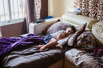 Little boy sleeping on bed couch in the morning