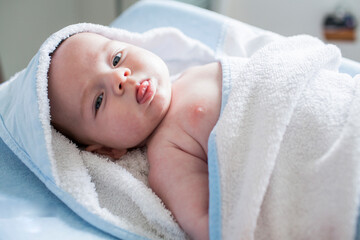 Baby boy wrapped in a towel after taking a bath