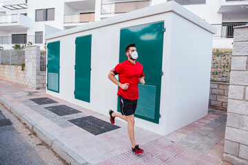 Mid adult man wearing face mask while running on footpath in city