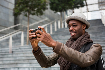 Smiling man taking selfie with smartphone