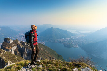 Rear view of hiker on mountaintop, Orobie Alps, Lecco, Italy - obrazy, fototapety, plakaty