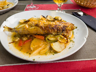 fish stewed with seafood and shells is on a plate in a restaurant