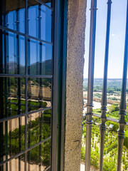 Fototapeta premium A regular park in the castle through a window with a metal grille