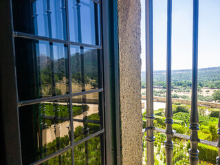 Fototapeta premium A regular park in the castle through a window with a metal grille
