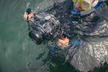 Man with underwater DSLR camera case in a lake