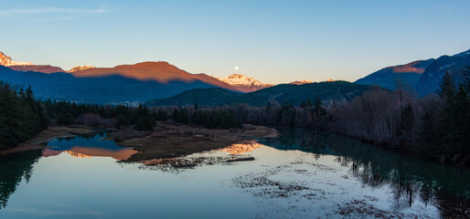 Canadian Mountain Landscape, peaceful river with green trees. Sunny Sunset.