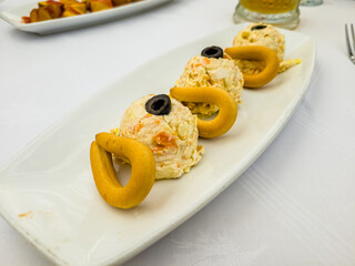 Russian salad with dried fruits is on a plate in a restaurant