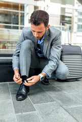 Businessman tying his shoes in the city