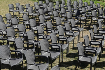 Naklejka premium rows of black plastic chairs outdoor furniture on lawn