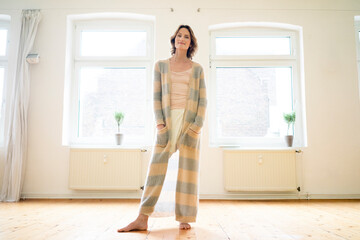 Portrait of smiling mature woman standing in empty room