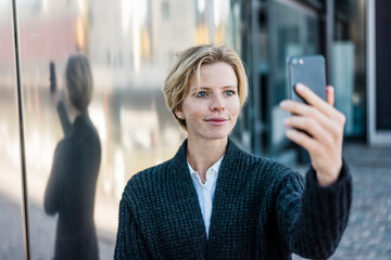 Young businesswoman taking selfie with her smartphone