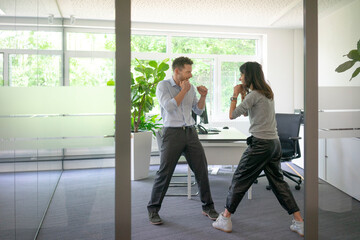 Businessman and businesswoman fighting in office