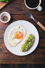 Toasts with mashed avocado and fried egg for breakfast
