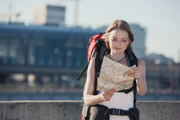 Germany, Berlin, Young woman with backpack looking at map