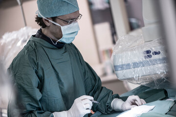 Neuroradiologist in scrubs holding scalpel
