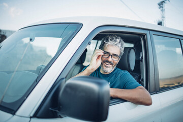Smiling mature man sitting in his off-road vehicle