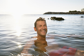 Portrait of smiling man bathing in the sea
