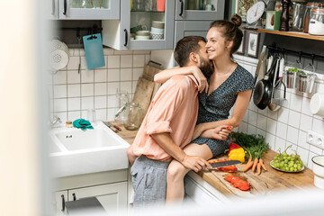 Affectionate couple in kitchen, preparing food