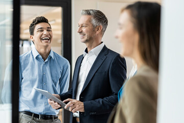 Smiling mature businessman and employees in office