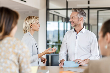 Businesswoman and businessman leading a meeting in office