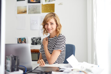 Obraz na płótnie Canvas Portrait of smiling blond business woman with laptop, sitting at desk