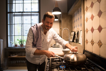 Portrait of smiling man cooking at home