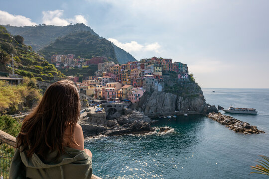 Italy, Liguria, La Spezia, Cinque Terre National Park, young woman looking to Manarola