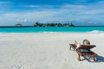 Maledives, Ari Atoll, Nalaguraidhoo, Sun Island Resort, back view of woman relaxing on the beach