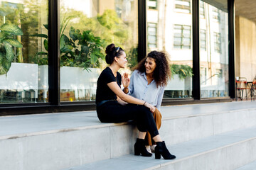 Two friends sitting on steps, gossipping