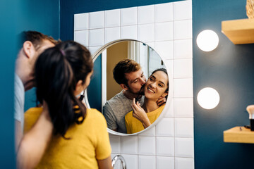 Affectionate young couple in bathroom at home - Powered by Adobe