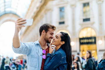 Obraz premium Happy young couple taking a selfie in the city, Milan, Italy