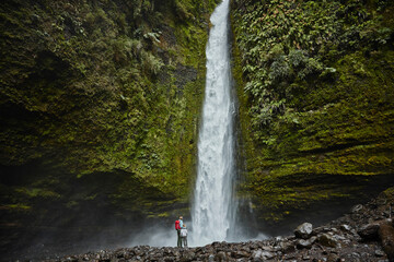 Chile, Patagonia, Osorno Volcano, mother and son standing at Las Cascadas waterfall
