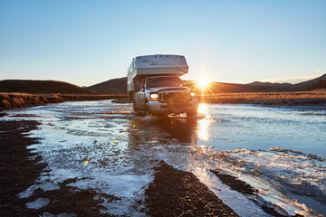 Chile, Tierrra del Fuego, Lago Blanco, camper crossing river at sunset in the steppe
