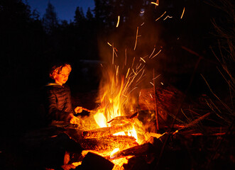 Argentina, Patagonia, Lago Futalaufquen, boy at camp fire at night