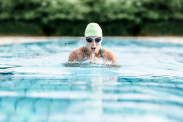 Young woman swimming in swimming pool, breast-stroke swimming