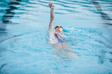 Young woman swimming in swimming pool, backstroke