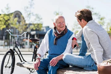 Fotobehang Senior man and adult grandson talking on a bench © tunedin