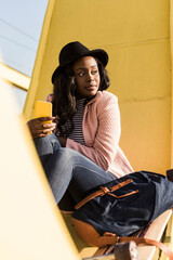 Young woman sitting on bridge using smartphone