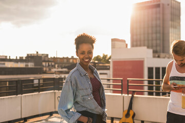 Portrait of smiling young woman on a rooftop party