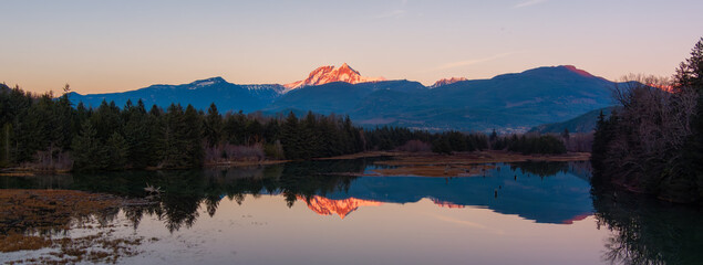 Canadian Mountain Landscape, peaceful river with green trees. Sunny Sunset