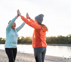 Grandmother and granddaughter high-fiving after training at the river