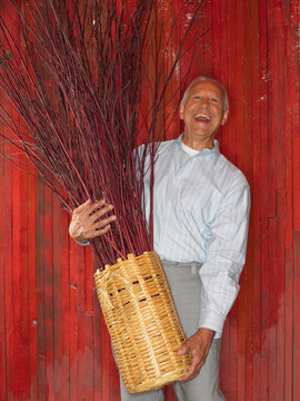 Man Holding Basket of Branches