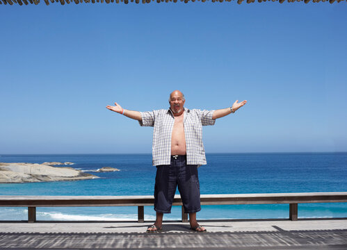 Man Standing by the Beach, Arms Raised in the Air